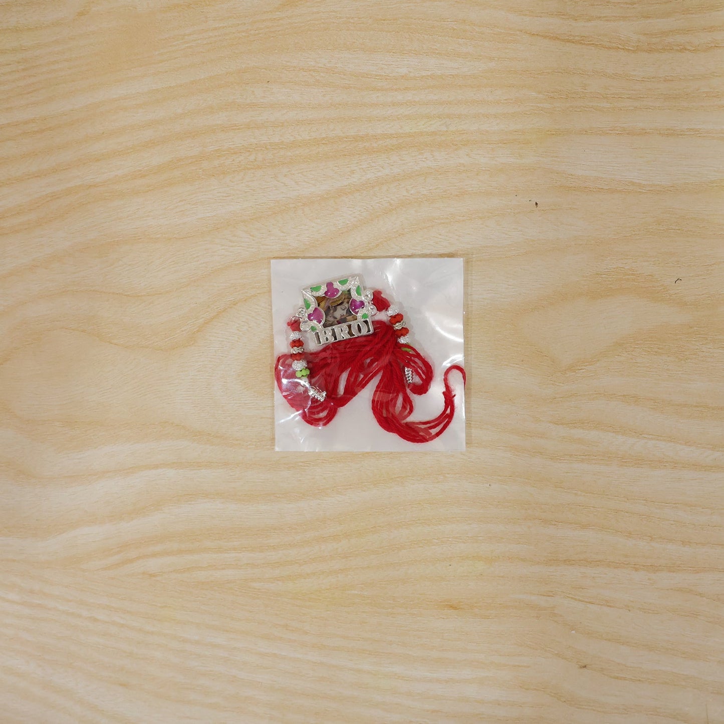 Back view of the 'Bro' Rakhi showing thread knot & frame