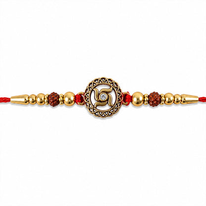 Golden Swastik Rakhi with Red Crystal Beads