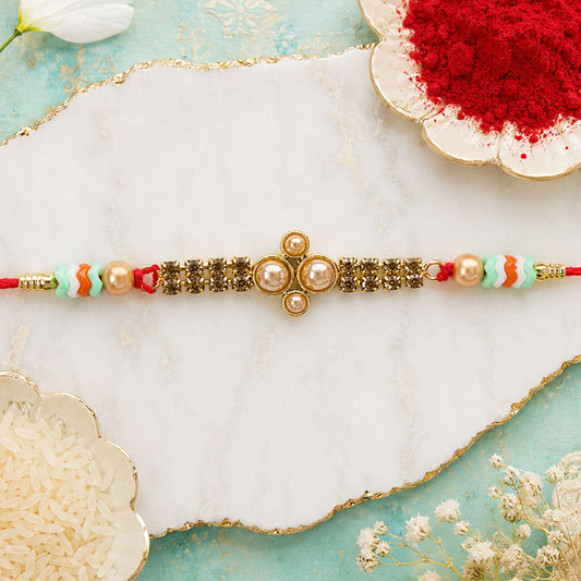 Close-up of a sparkling Kundan Rakhi for brother featuring pearls and crystal beads.