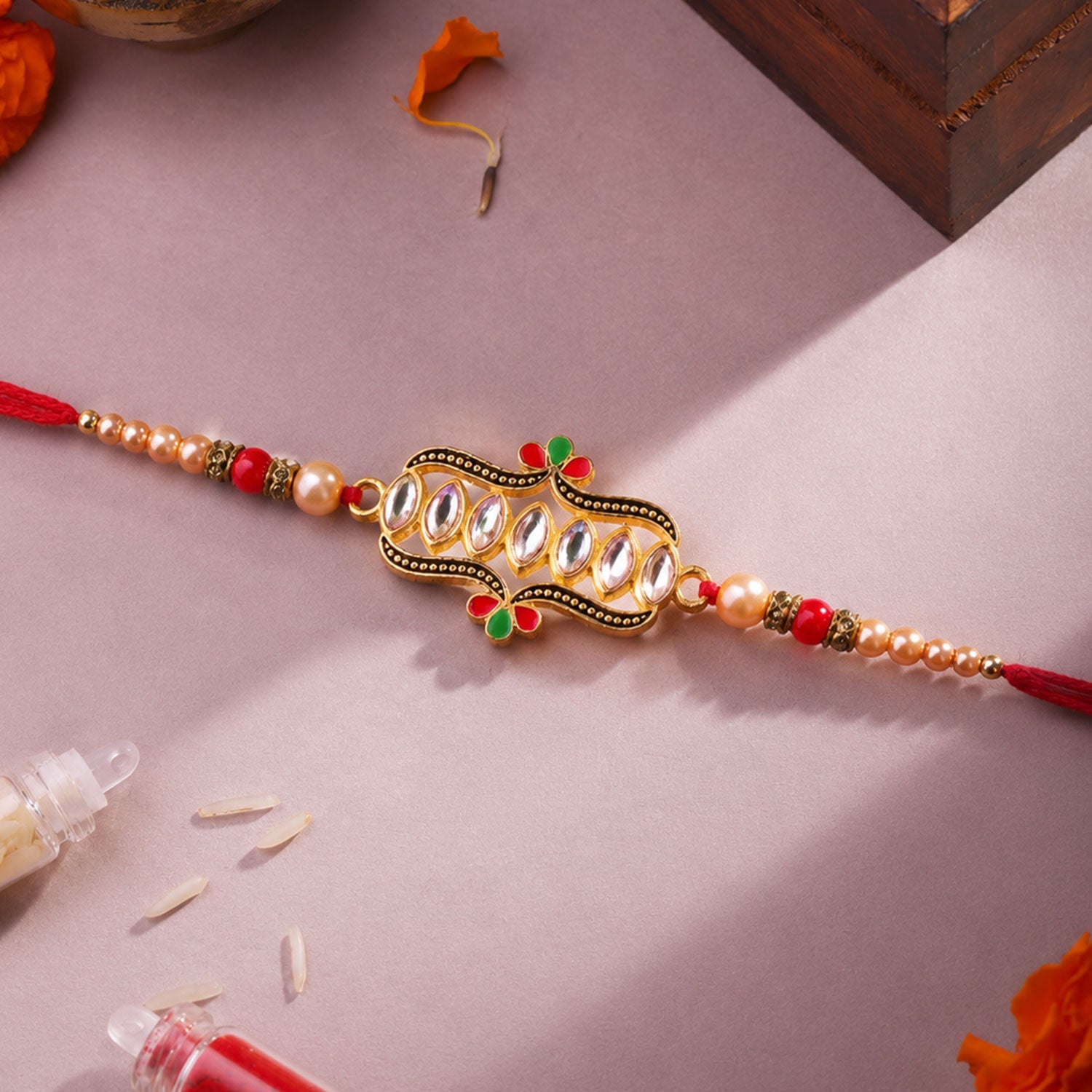 Kundan designer Rakhi displayed with festive elements and beads.