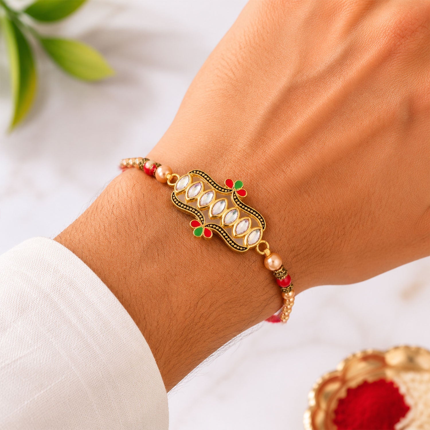 Kundan stone Rakhi tied on a brother's wrist for Raksha Bandhan.