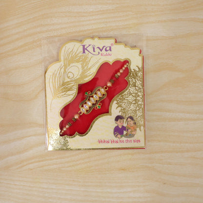 Side angle of the designer Rakhi, highlighting its studded kundan stones.
