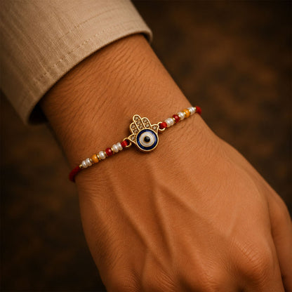 An Evil Eye Rakhi with pearl bead work displayed from a slightly different angle.