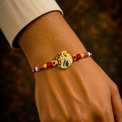 Peacock Charm Rakhi for Brother displayed with its colourful bead embellishments.