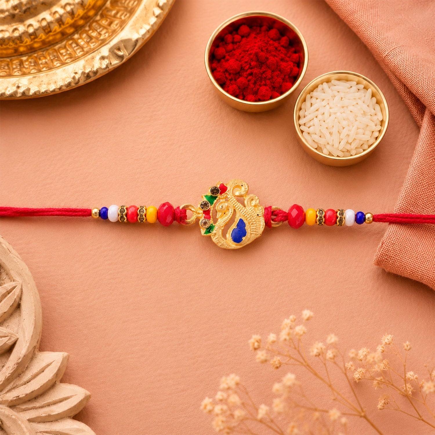 Overhead view of the designer Rakhi, highlighting the vibrant peacock charm and thread work for Raksha Bandhan.