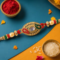 Kundan Rakhi for Brother – Golden Oval Meenakari & Pearl Design