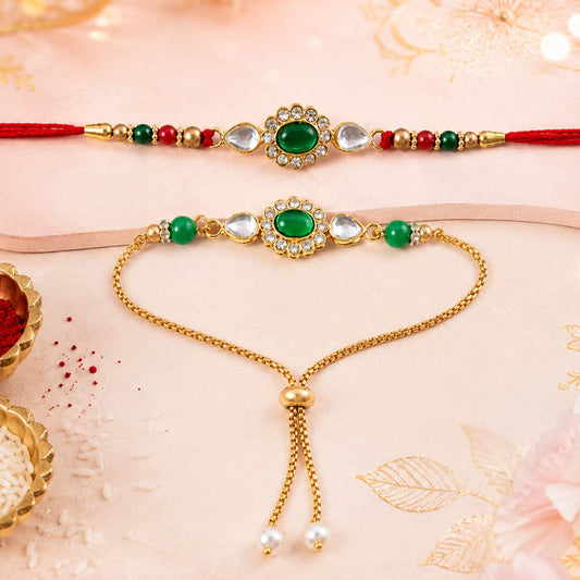A red-threaded Rakhi and a gold bracelet, both featuring an oval green stone surrounded by clear gems, lie on a pink surface.