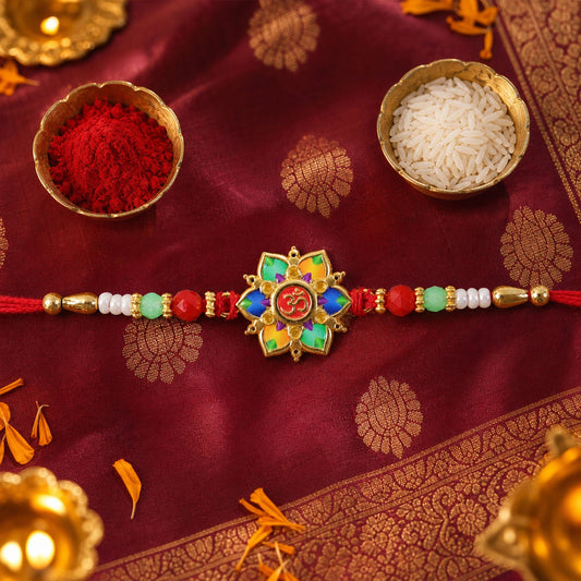 A vibrant multicolor lotus design with an Om symbol at its center, flanked by red, green, and white beads on a red thread,