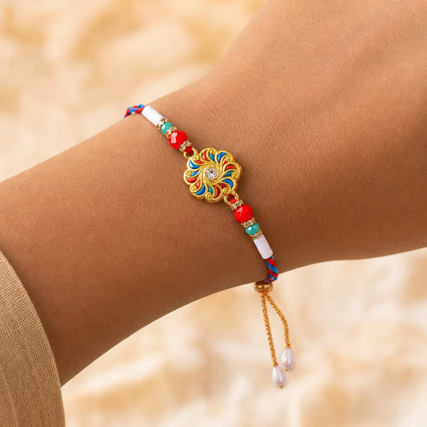 A person's wrist wears a colorful floral bracelet with red, teal, and white beads, and pearl drops on a gold chain.