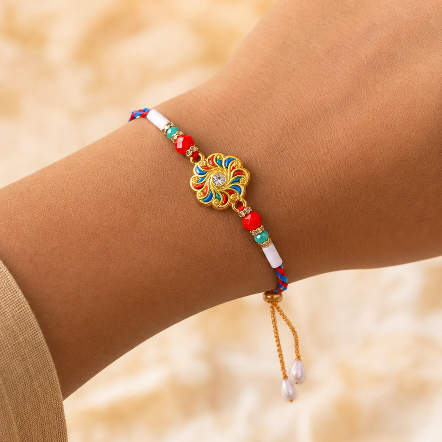 A person's wrist wears a colorful floral bracelet with red, teal, and white beads, and pearl drops on a gold chain.