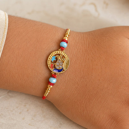 Round Peacock Motif Rakhi with Beaded Sacred Center Charm Design