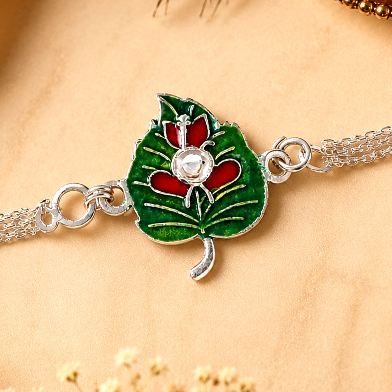 Leaf Ganesha Motif Stone Rakhi with Elegant Chain Center Detail Design