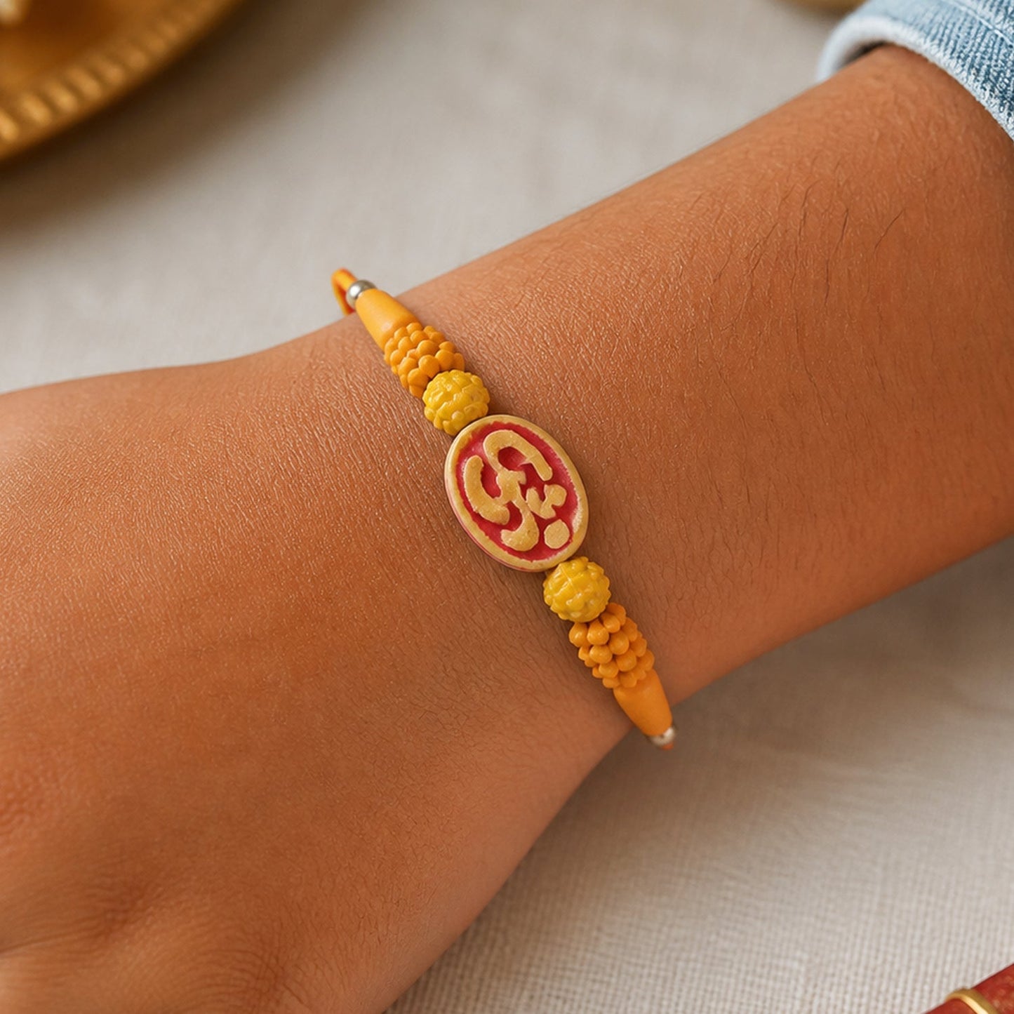 Divine Om Designer Rakhi with Golden Beads for Brother