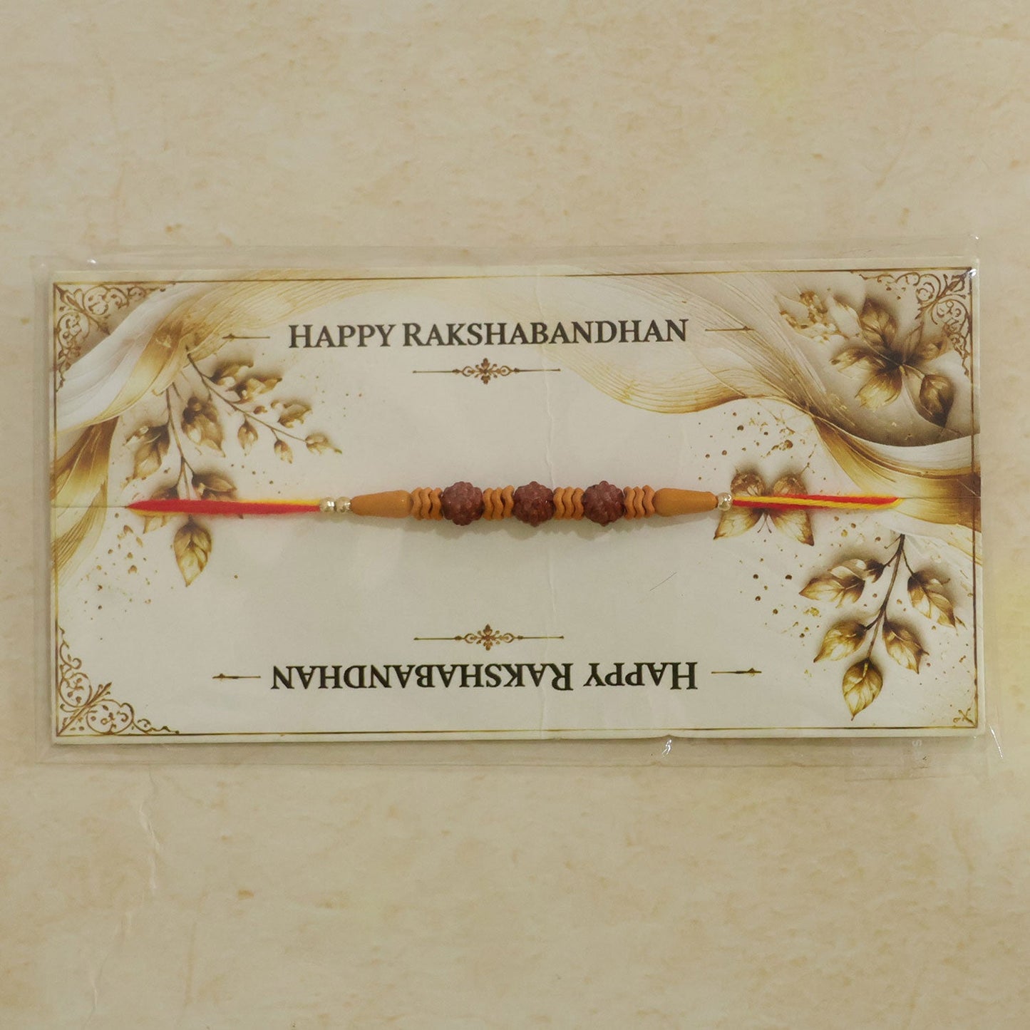 A Rudraksha Rakhi on a decorative card with