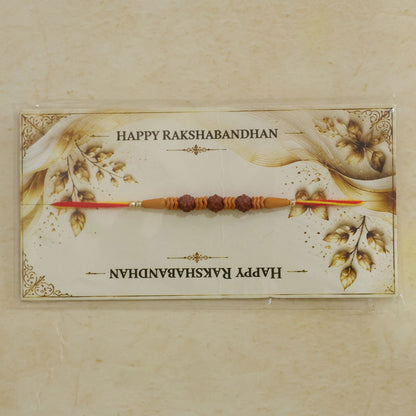 A Rudraksha Rakhi on a decorative card with