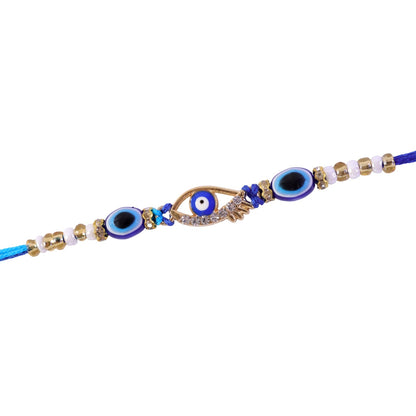 A blue evil eye rakhi with a gold and rhinestone center charm, accompanied by smaller blue evil eye beads and white and gold