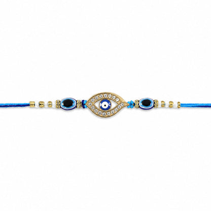 A blue evil eye rakhi with a stone-studded center charm and blue and white beads on a plain white background.