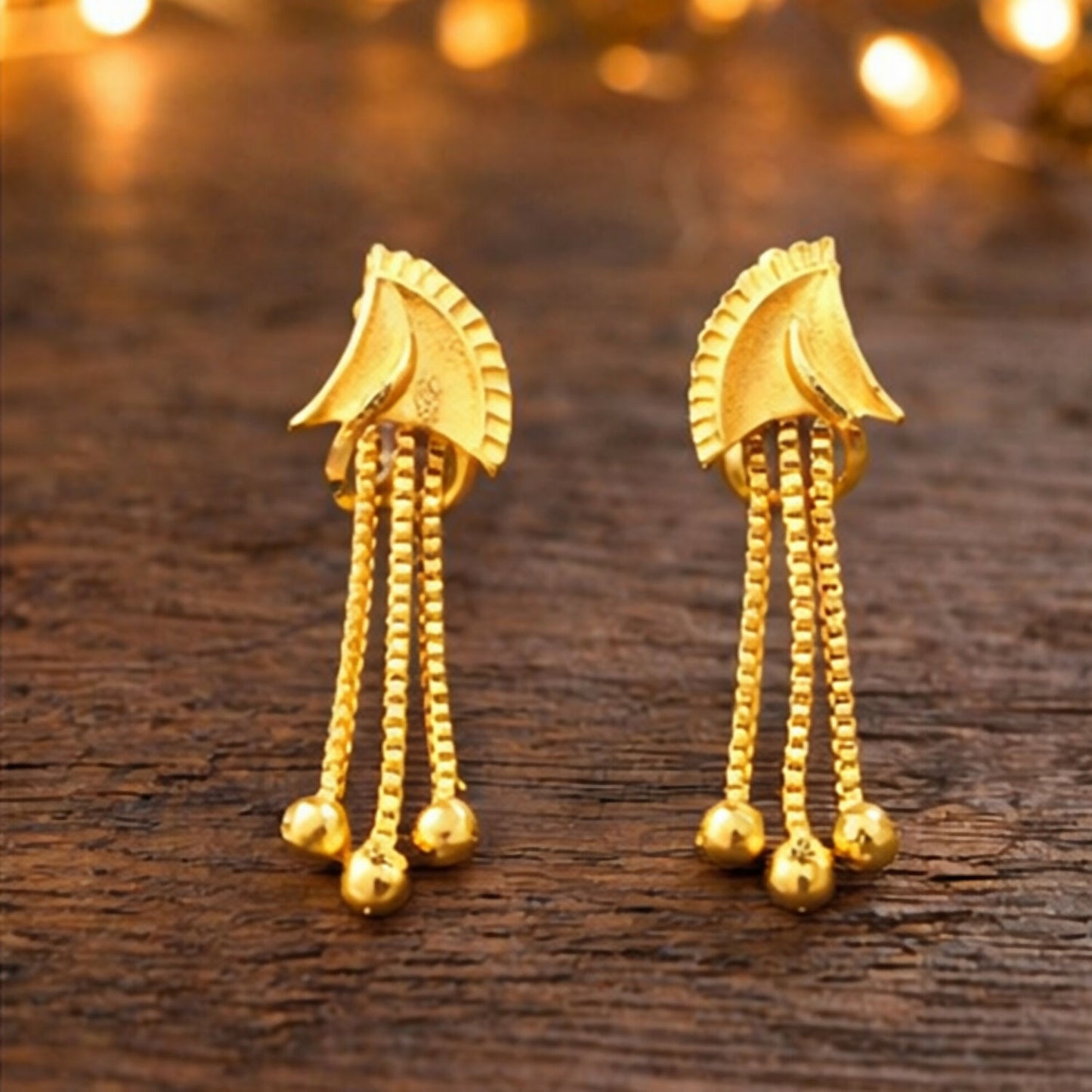 Front view of lightweight golden drop earrings with detailed stone work