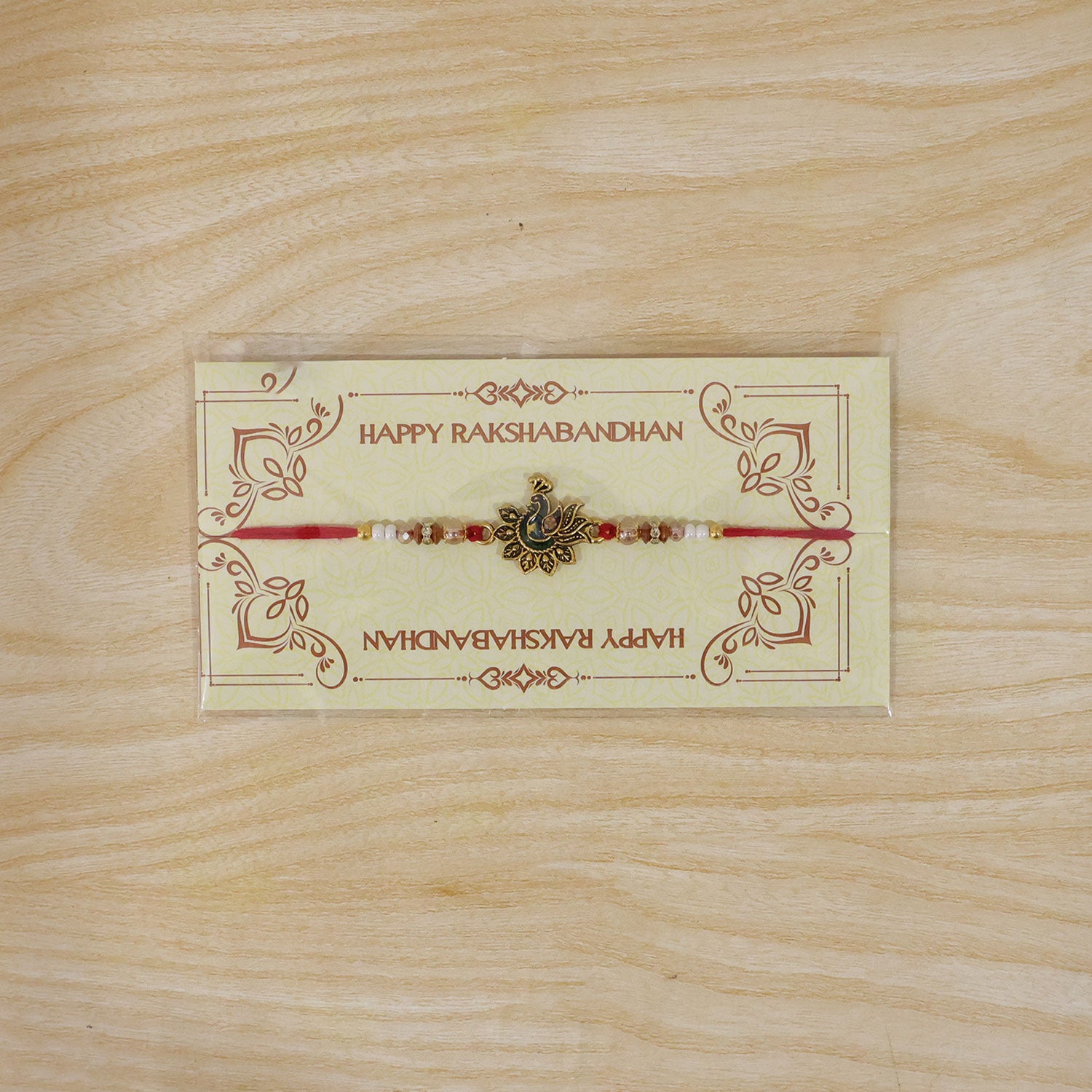 Peacock Floral Golden Rakhi with Blue Green Enamel, Pearl Beads and Red Thread