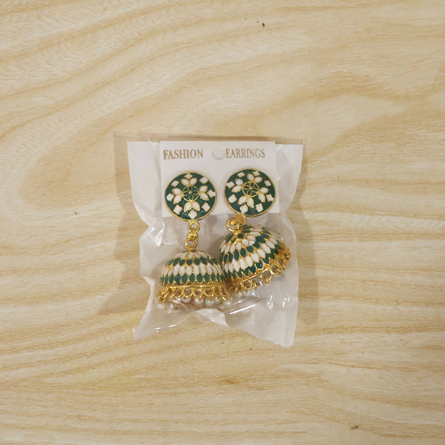 Model wearing green round stud jhumka earrings with pearl drops