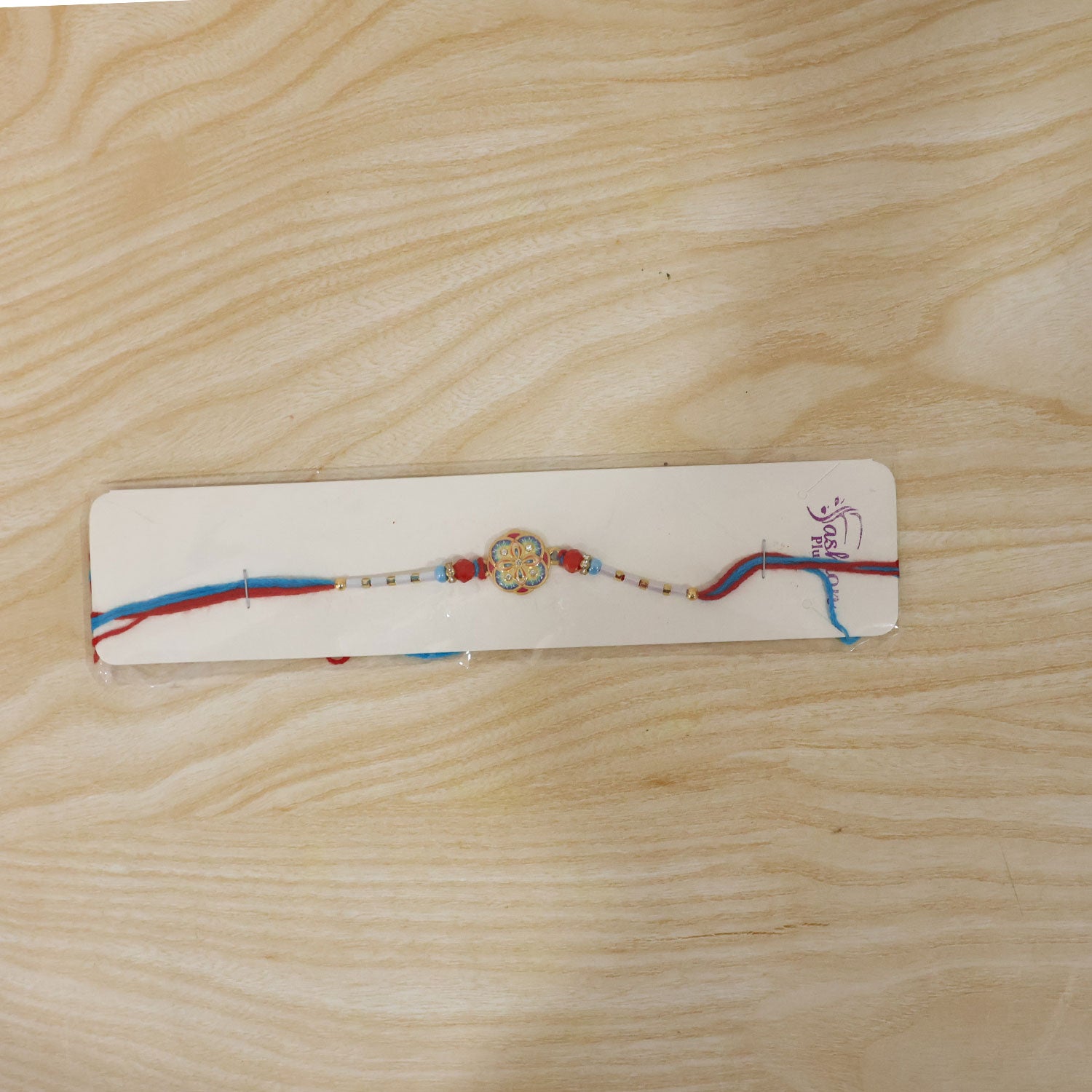 Colorful Kundan Round Rakhi with Red Beads and Blue Thread Edges