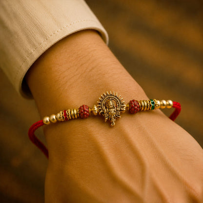 Ganesh Ji Antique Golden Devotional Rakhi with Red Beads and Pearl-Style Accents