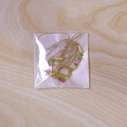Golden Circular Rakhi with Pink Green Beads and Refined Festive Brother Gift Appeal