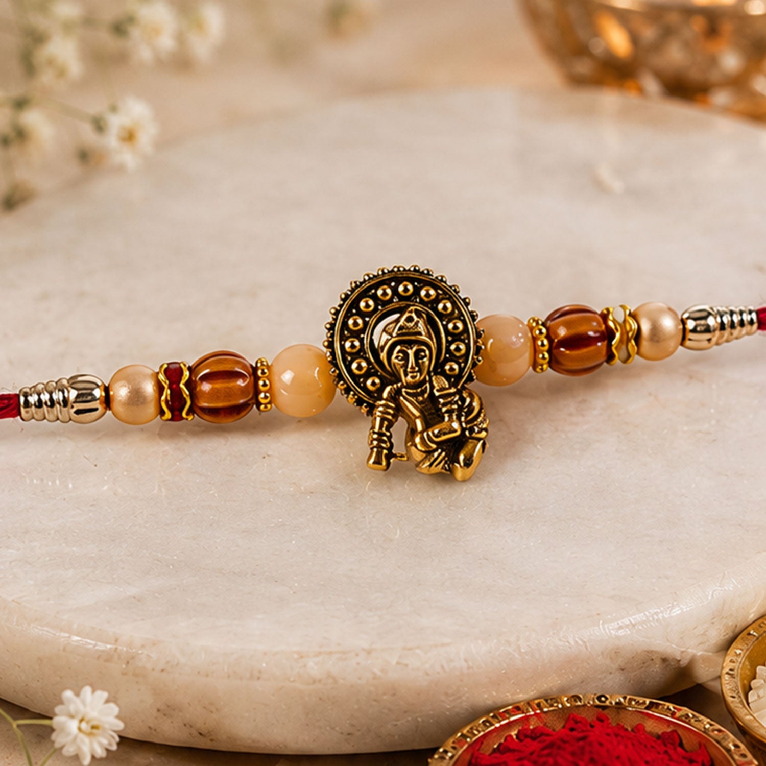 Antique Deity Idol Devotional Rakhi with Golden Medallion, Peach Beads and Red Thread