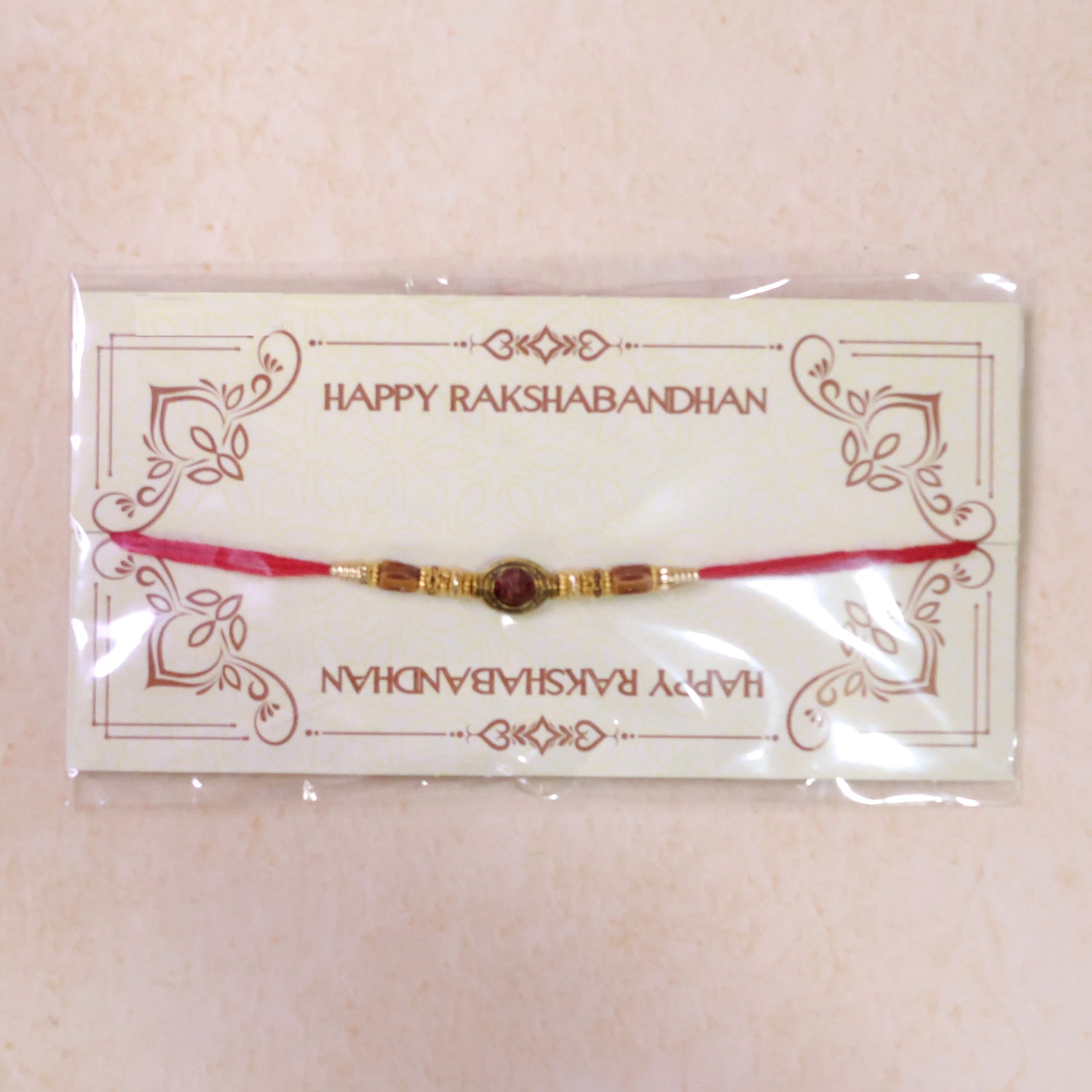 Red Thread Rakhi with Amber Beads and Antique Gold Oval Charm