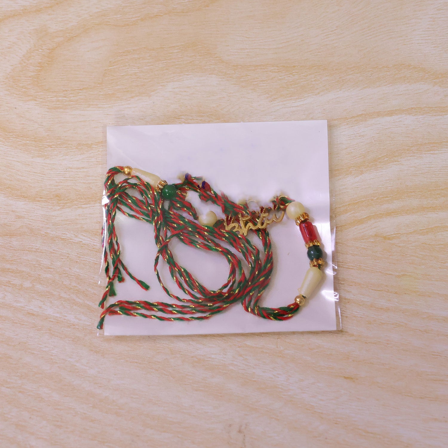 Bold Rakhi showcasing Devanagari Script Charm, bead line and plaque look for Gift Use
