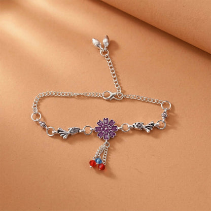 Silver flower charm bracelet with purple flower center and beads