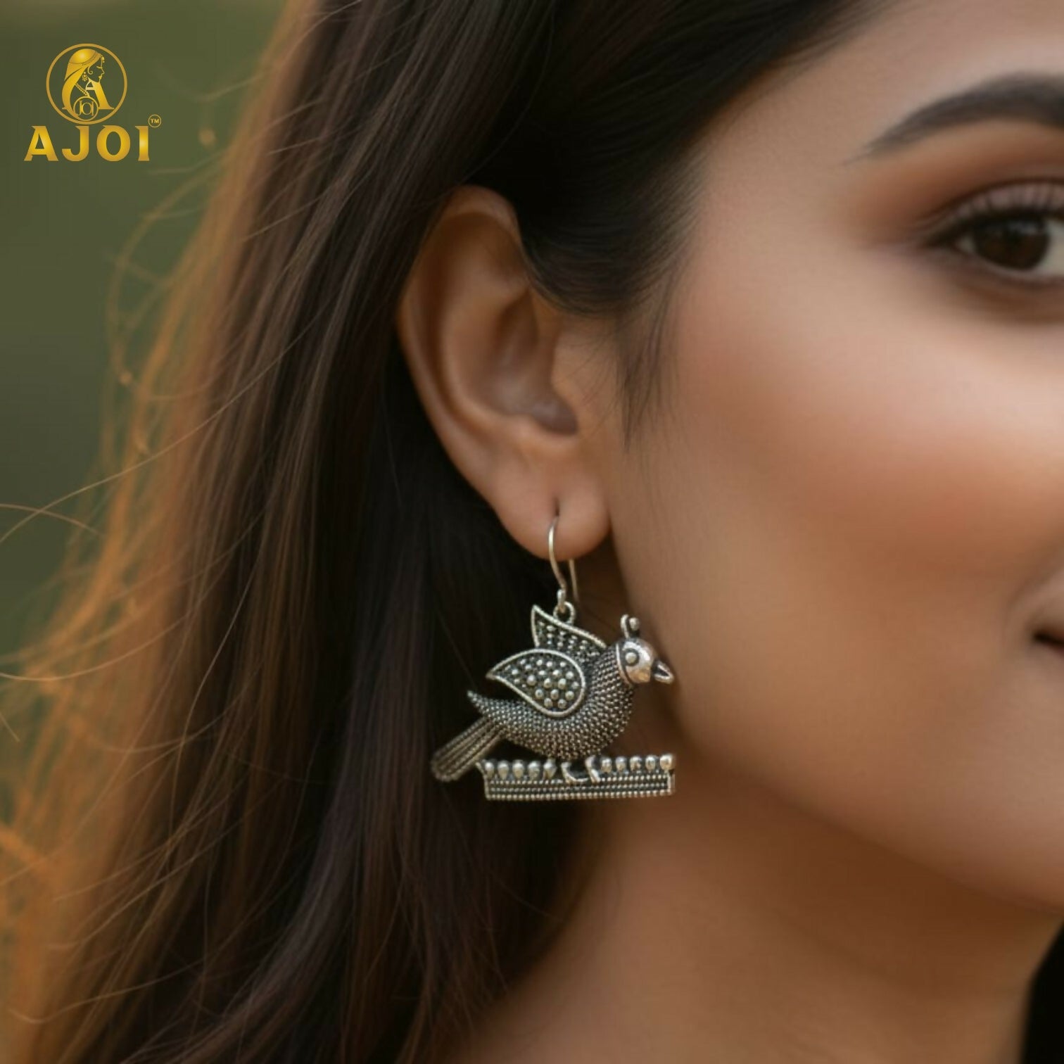 Detailed close-up of oxidized silver peacock motif earrings