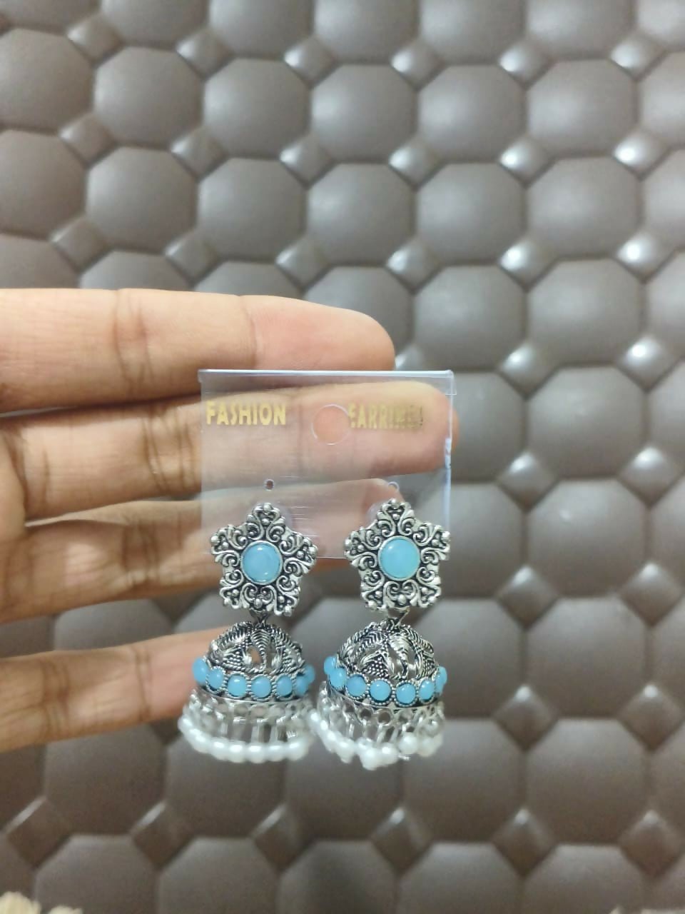 Model wearing silver oxidized light blue jhumka earrings