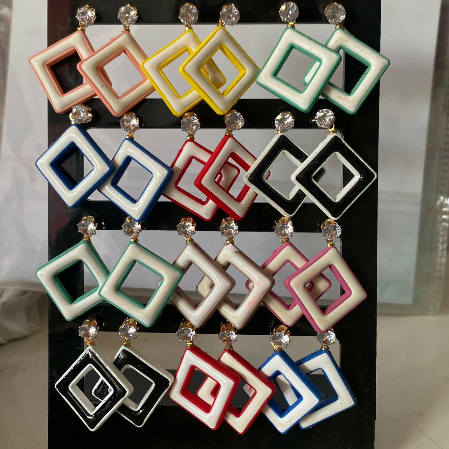 Assorted trendy geometric earrings with different crystal colours.