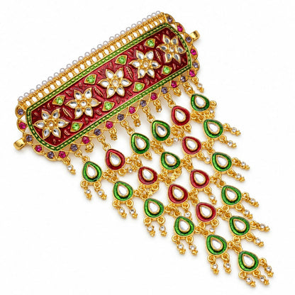 A gold-plated choker necklace with a red and green floral meenakari design and numerous dangling teardrop charms, on a white