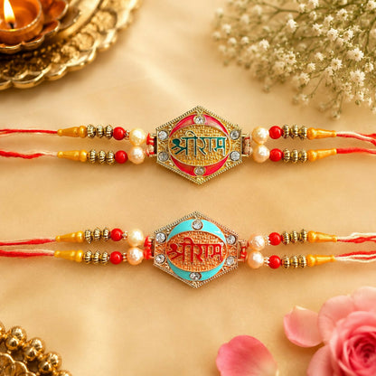Two designer Rakhis with pearl beads and gold and rose gold finish, one with a green center and one with a blue center, on a