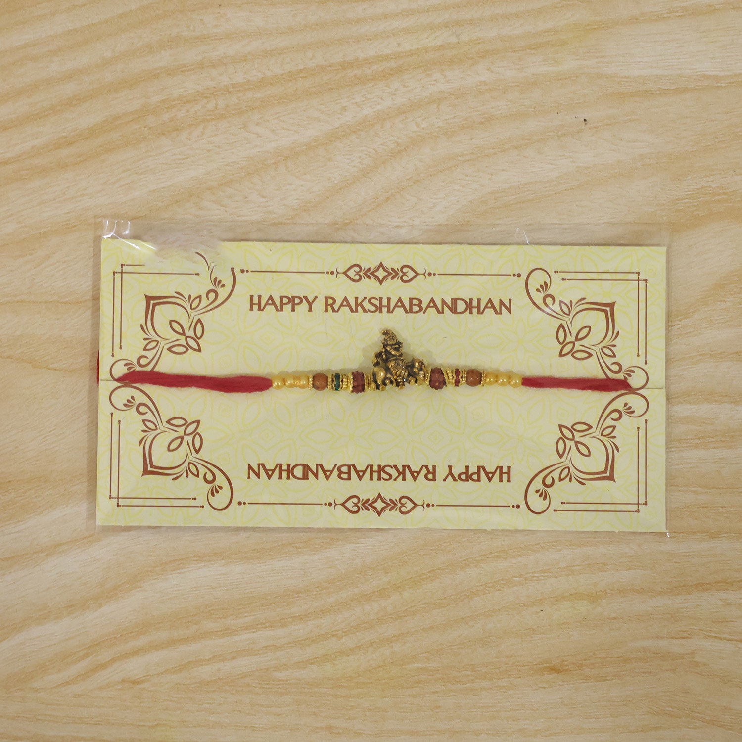 Bal Krishna Golden Devotional Rakhi with Idol Centre, Red Beads and Pearl Accents