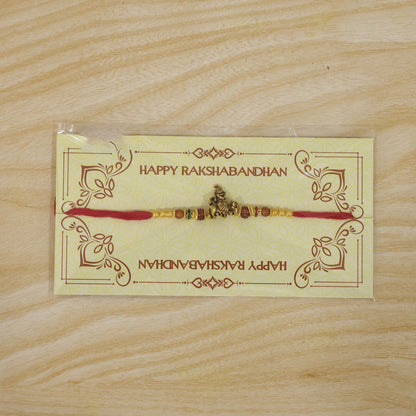 Bal Krishna Golden Devotional Rakhi with Idol Centre, Red Beads and Pearl Accents