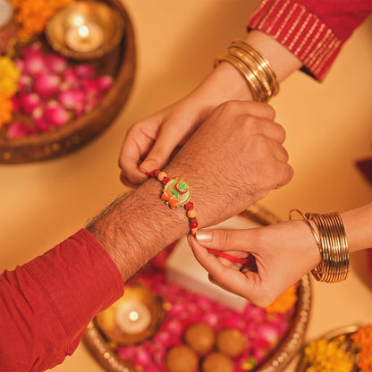 Trishul Damru Rakhi with Peach Beads and Red Thread