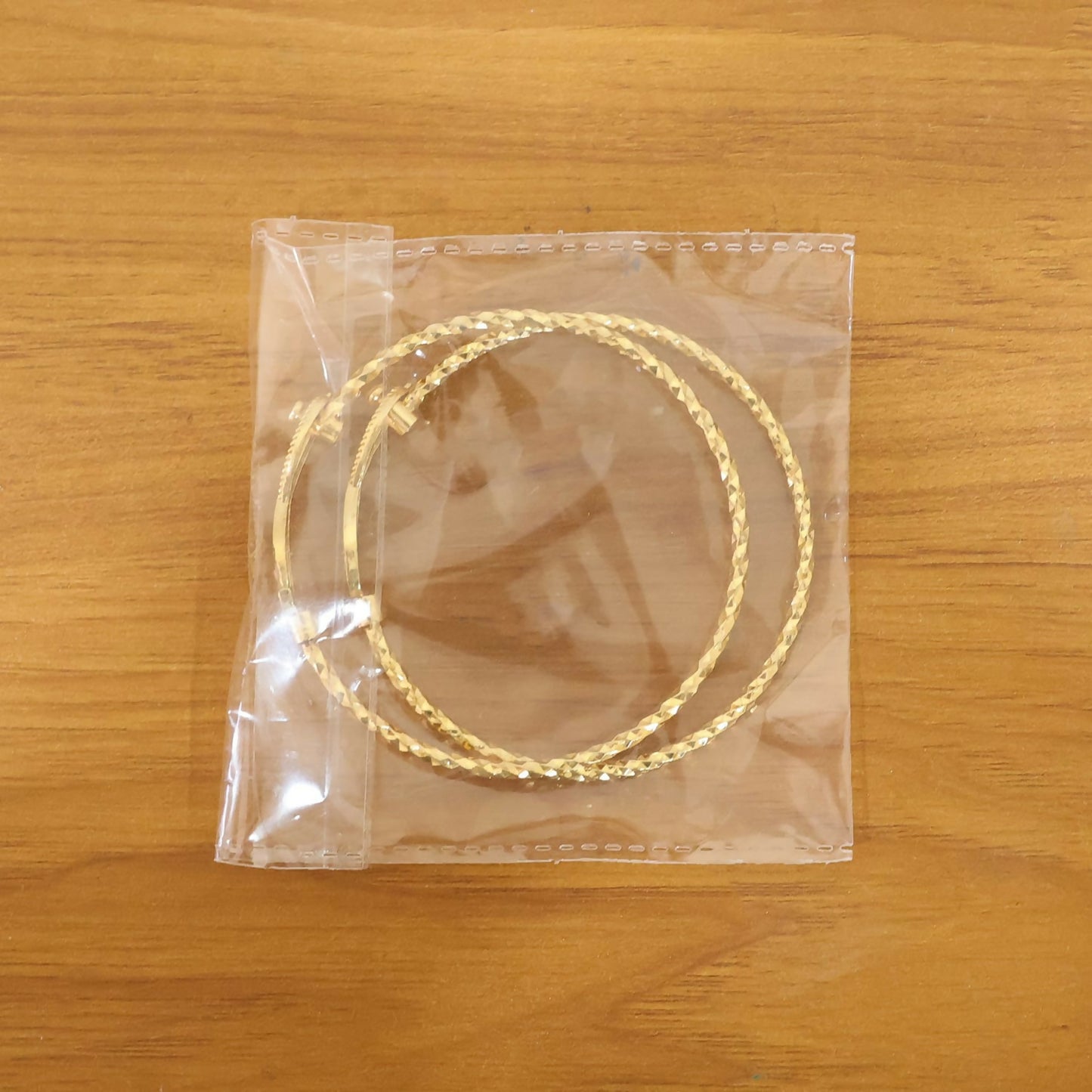 Elegant gold infinity stone bracelet pair on display stand