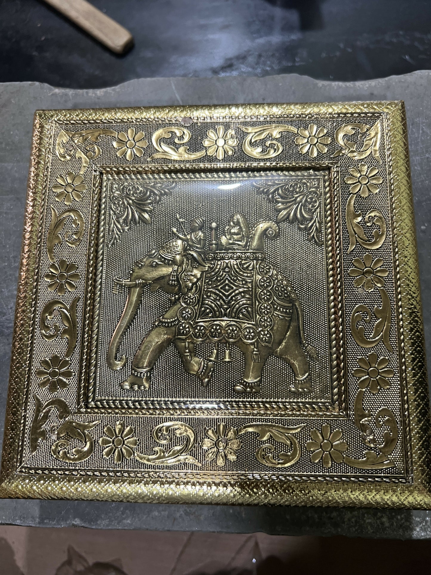 Close-up of intricate elephant Ambari embossed pattern on golden jewelry box