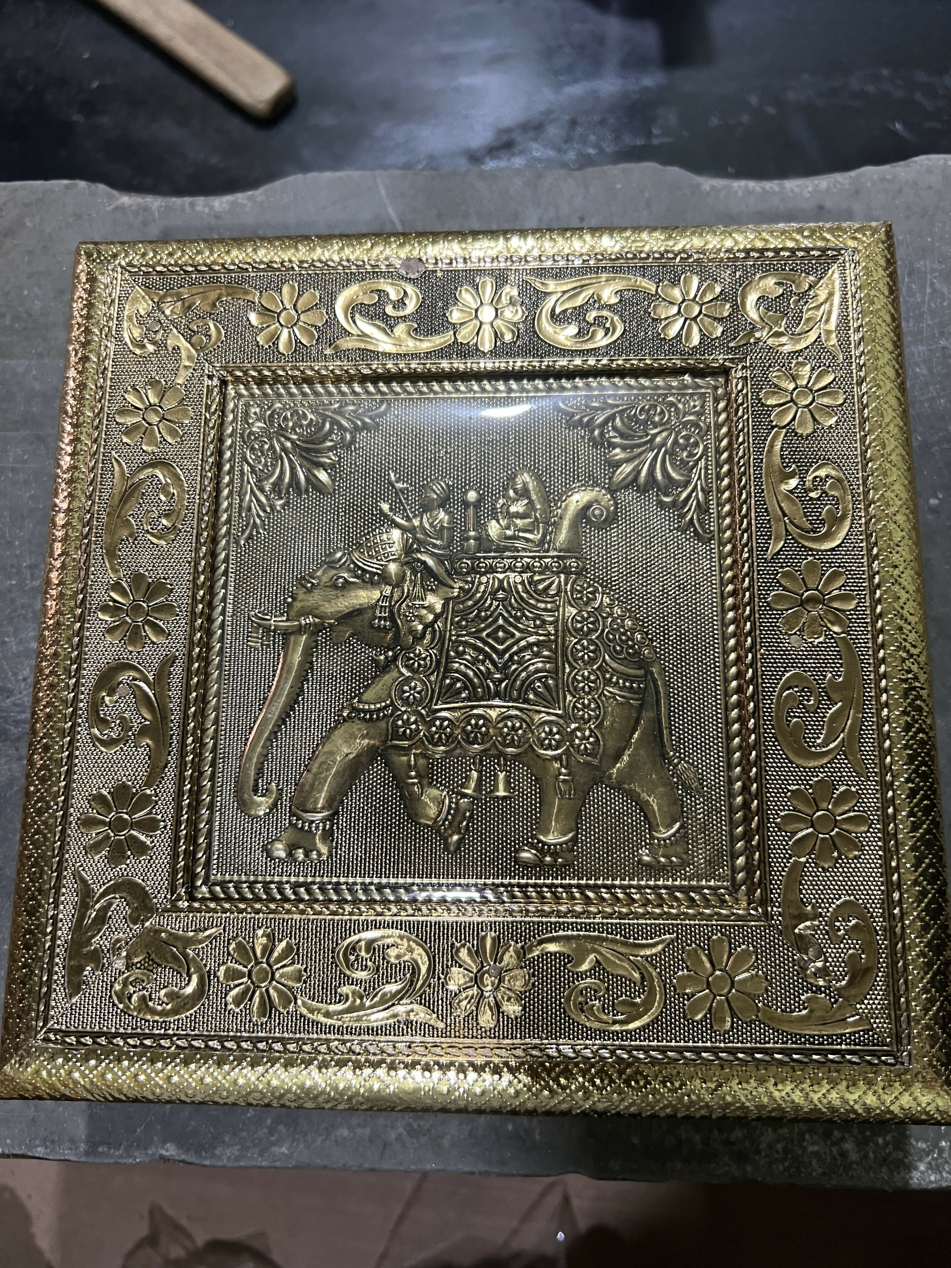 Close-up of intricate elephant Ambari embossed pattern on golden jewelry box