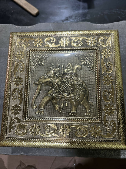 Close-up of intricate elephant Ambari embossed pattern on golden jewelry box
