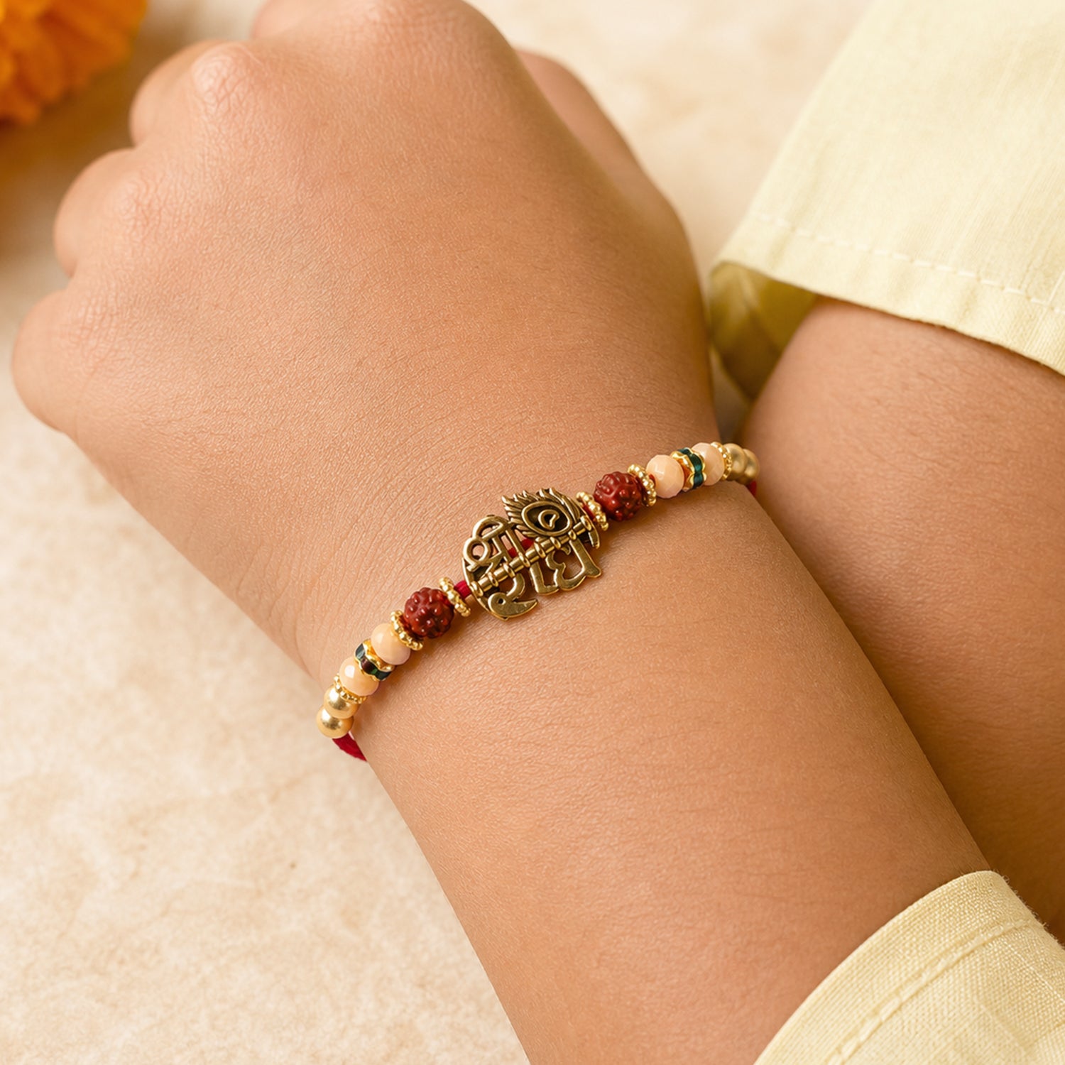 Red Thread Rakhi with Antique Gold Radhe Pendant and Peacock Feather