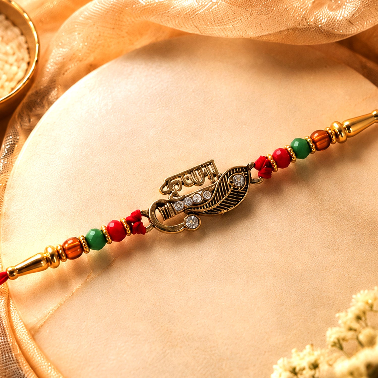 Veera Name Rakhi with Flute Leaf Style Centre, Stones and Red Green Beads