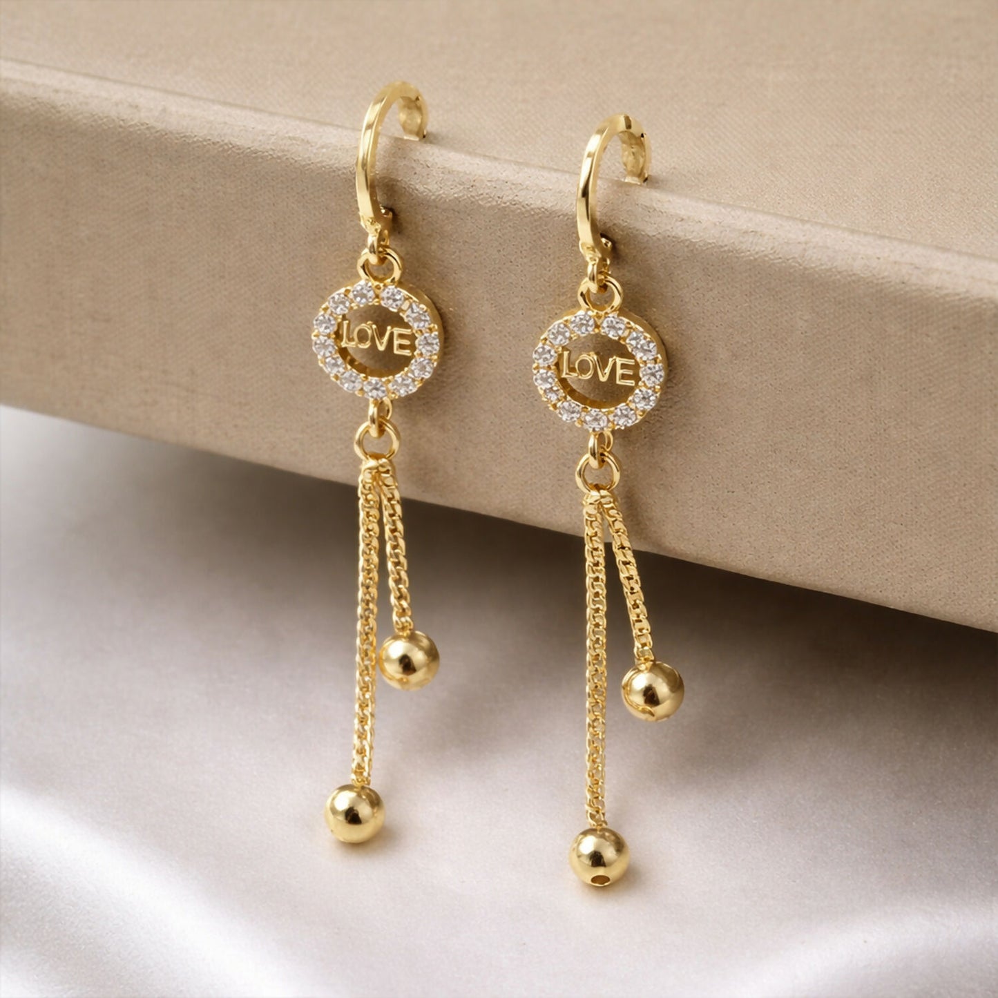 Front view of Love Charm Tassel Earrings featuring a “LOVE” charm and flowing tassels