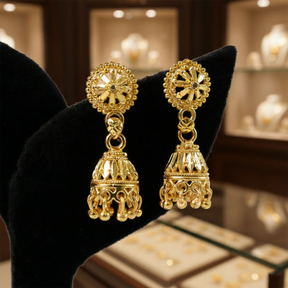 Side view of traditional gold plated jhumka earrings with hanging beads