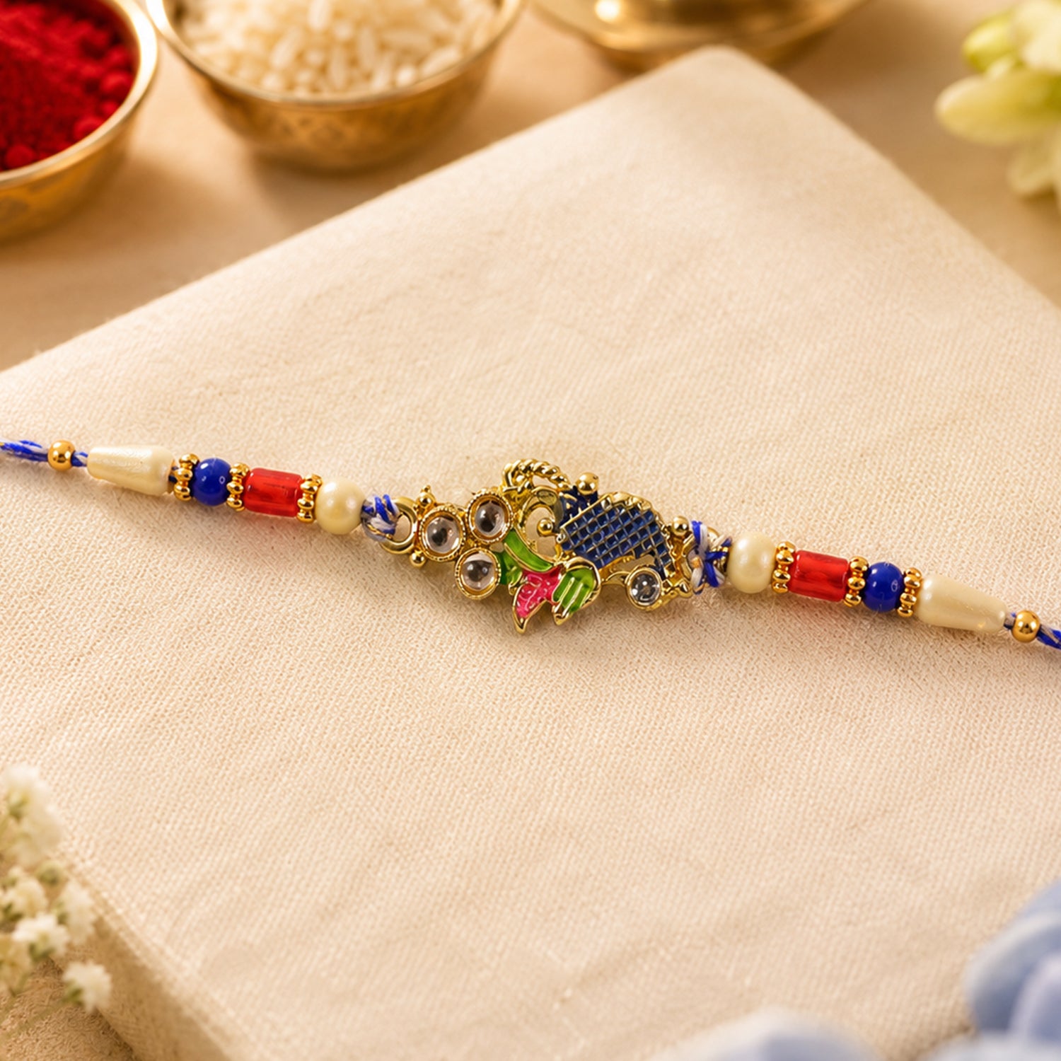 Peacock Motif Rakhi with Red Blue Beads and Elegant Traditional Gift Presentation