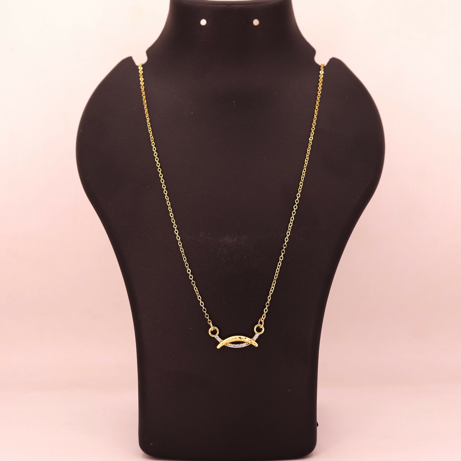 Delicate gold chain necklace with a fish-shaped marquise pendant and CZ stones