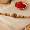 Golden Om Rakhi for Brothers with Peach Beads and Red Thread
